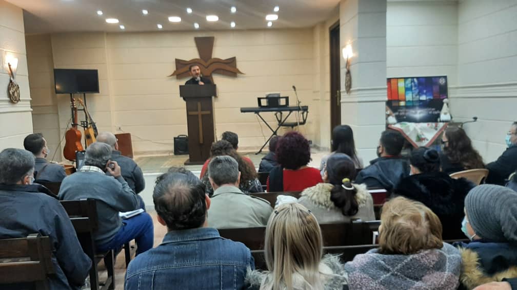 A speaker teaching a seated congregation